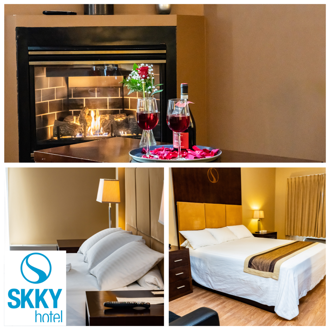 SKKY Hotel in Whitehorse, Yukon. Three images of a room with a king-size bed, a picture of a fireplace with wine glasses on a table, and a side view of the pillows on a bed.